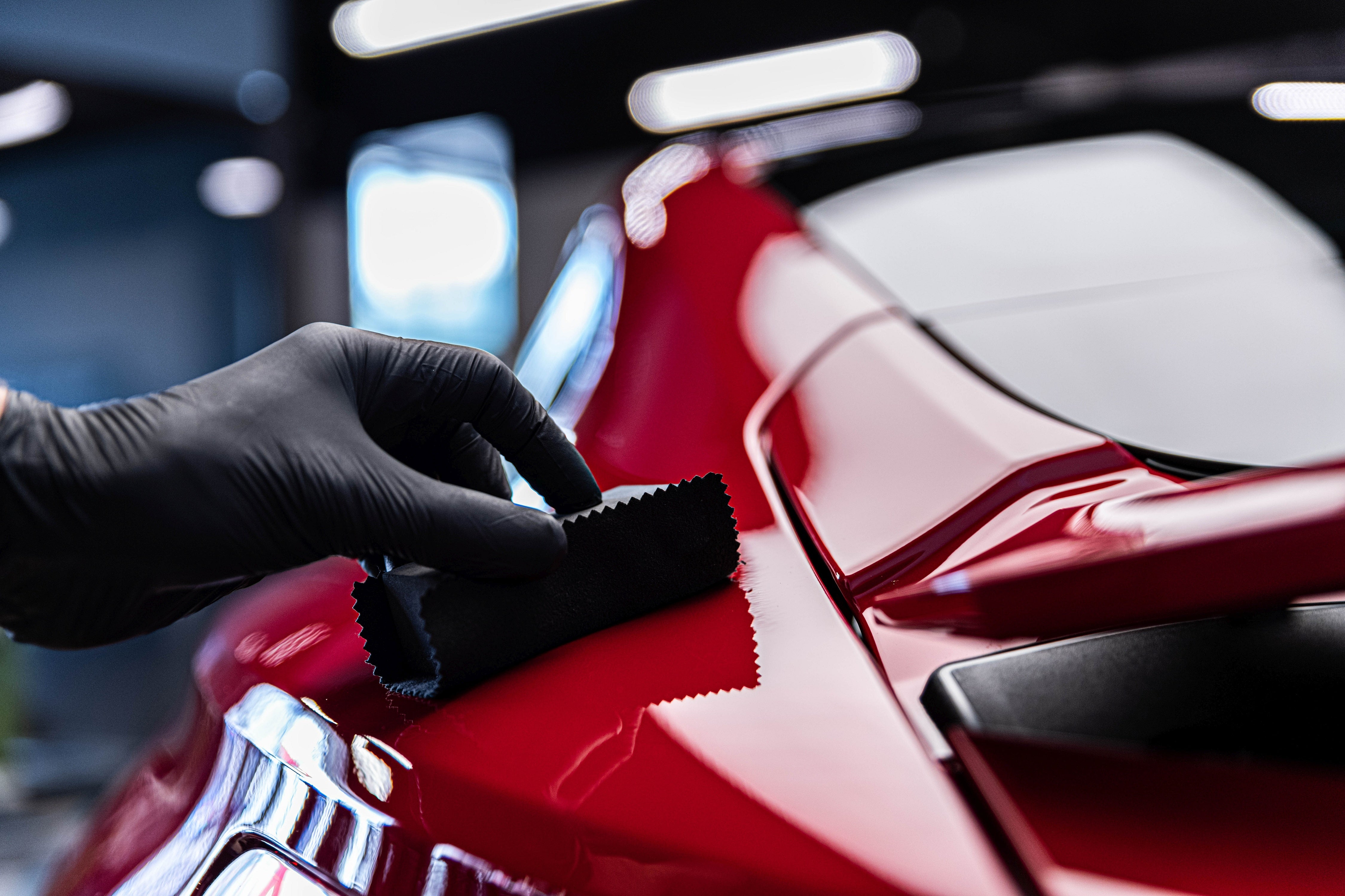 Water beading on a freshly ceramic-coated black BMW hood