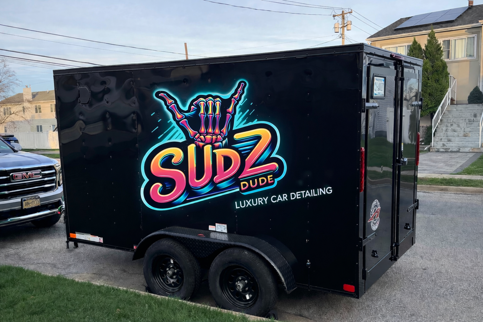 The SUDZ DUDE mobile detailing trailer parked at a customer's home